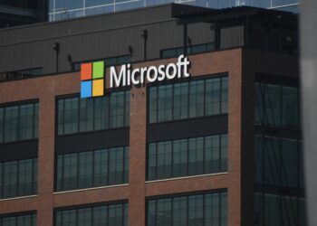A tall building with a microsoft logo on top of it