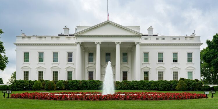 A large white building with a fountain in front of it