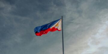 a flag flying in the wind on a cloudy day