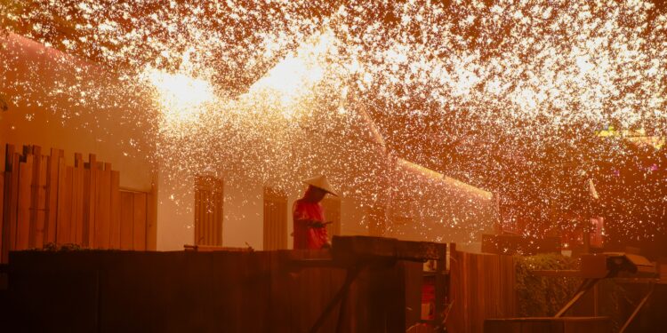 Fiery explosion over a dark cityscape at night.
